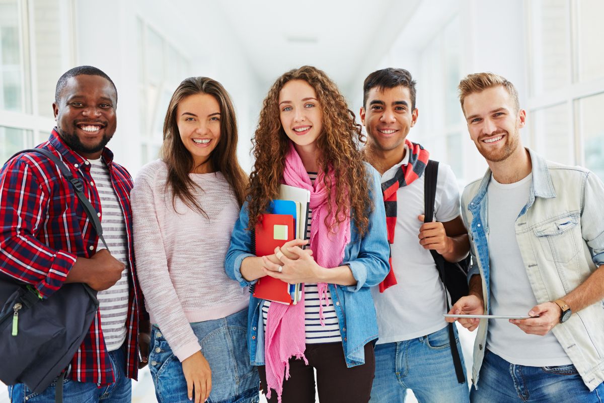 The photo of a group of college students with their bags, notebooks, and a tablet which refers to learning how to get paid for school teaching your child financial skills, and helping them plan can be just as valuable as saving up.
