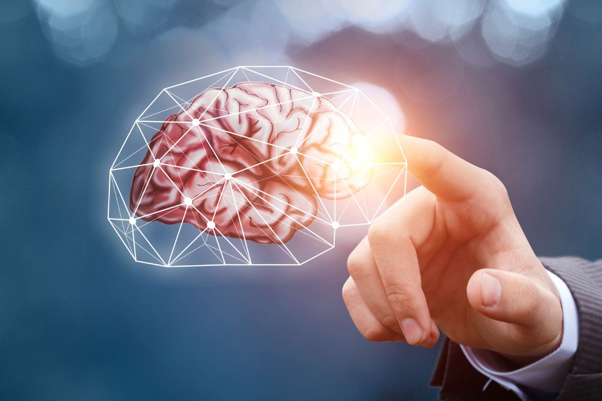 The photo shows a man's hand pointing to the visual brain graphic which refers to mindset plays a crucial role makes financial improvement feel doable instead of overwhelming.