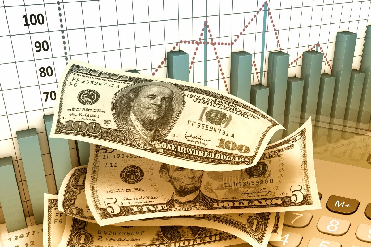 The image shows a graph with numbers, a calculator, and dollar bills which means investing consistently builds a habit of putting money toward future goals.
