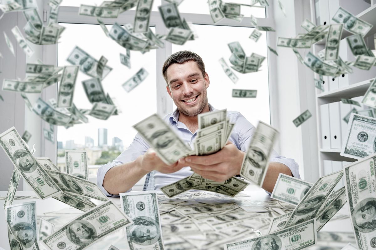 The picture of a man enjoying loads of dollars which refers to visualizing yourself living in financial prosperity builds confidence, reduces fear, and encourages smart financial moves.