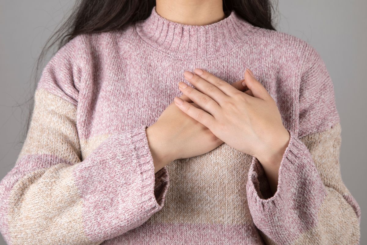 The photo shows a girl putting her hands on her chest referring to feeling gratitude for the money you already have helps money flow more easily into your life.