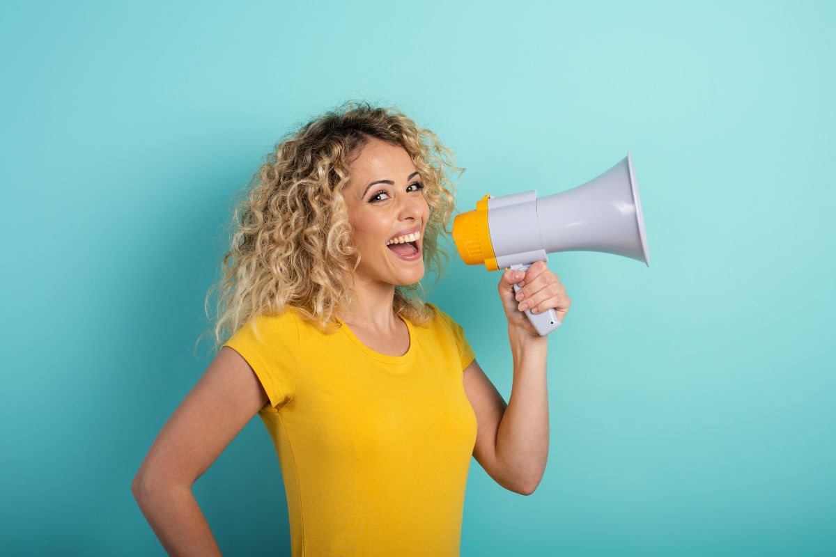 The image tells about a girl using a loudspeaker which means speaking about money positively influences and how it comes to you.