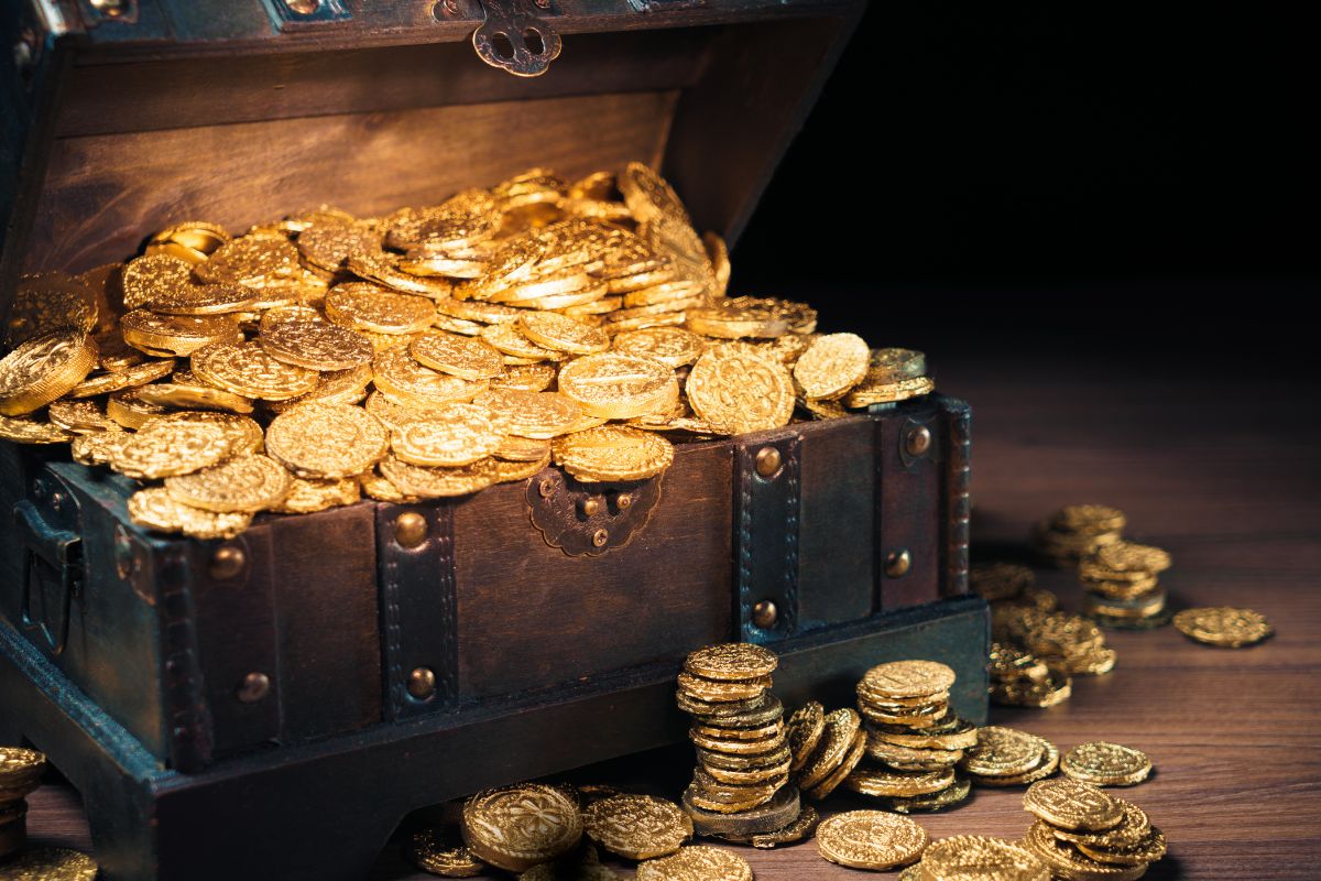 The image shows a treasure chest with coins which means focusing on abundance rather than scarcity helps attract more money by keeping you open to new possibilities.