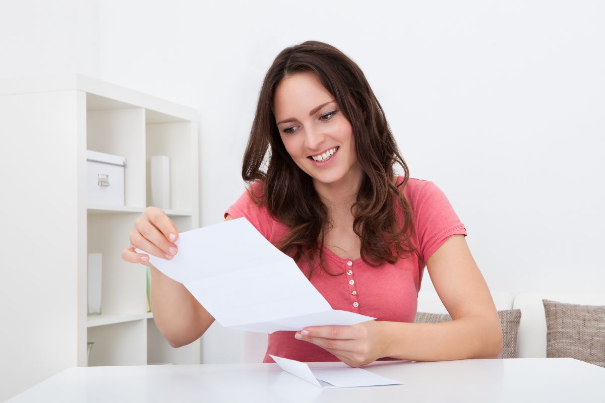 The image tells about a girl holding a piece of paper referring to how repeating these money mantras helps keep your mind focused on abundance.