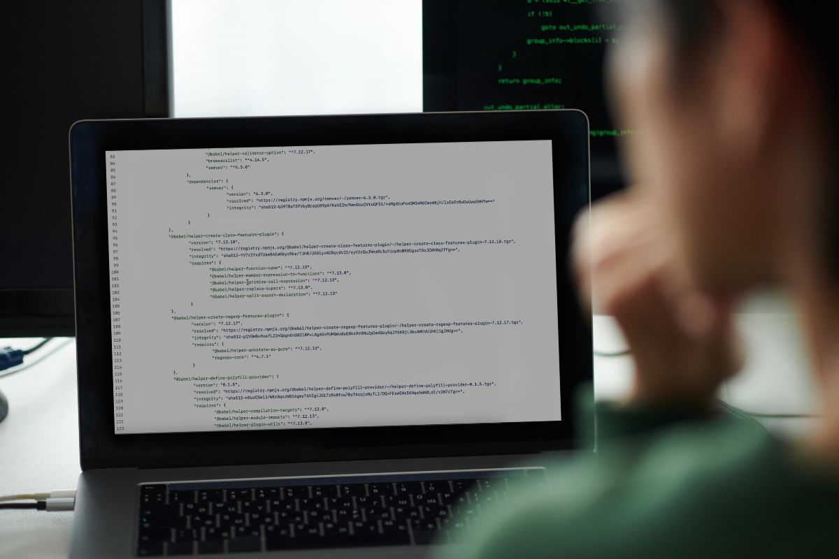 The photo of a man working as a DevOps Engineer on a laptop.