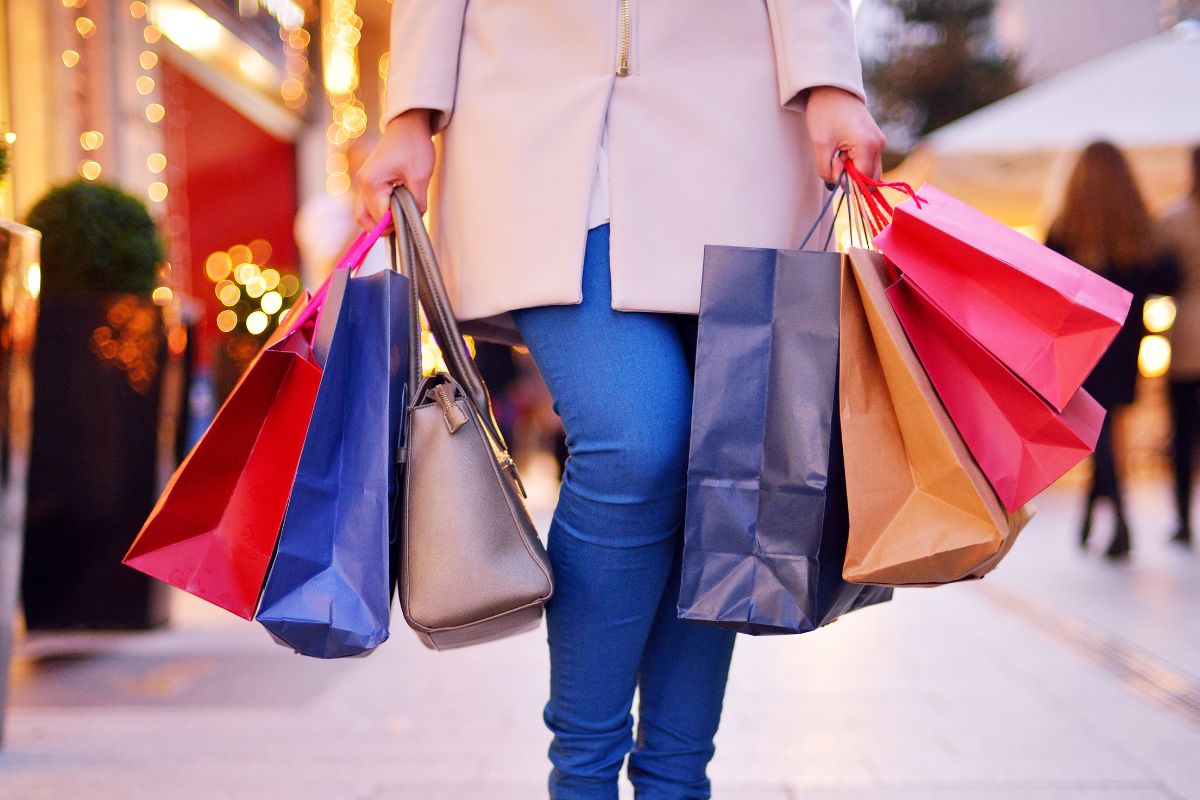 The photo shows a girl carrying shopping bags at the mall which refers to no spend month, which helps break impulsive spending habits and help build financial control.