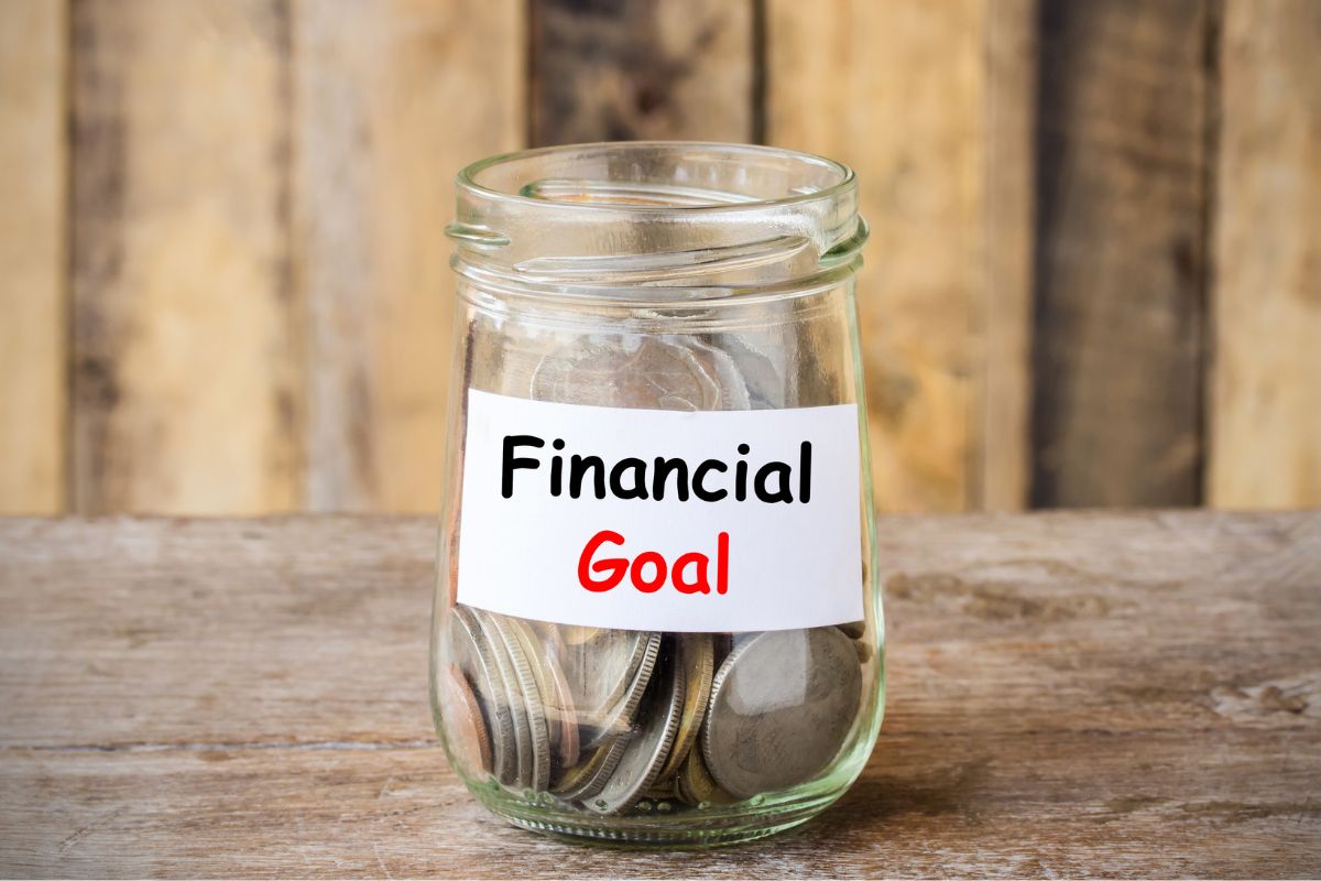 The photo shows a jar filled with coins and notes referring to no spending month strengthens financial goals and priorities and can help build habits that last.