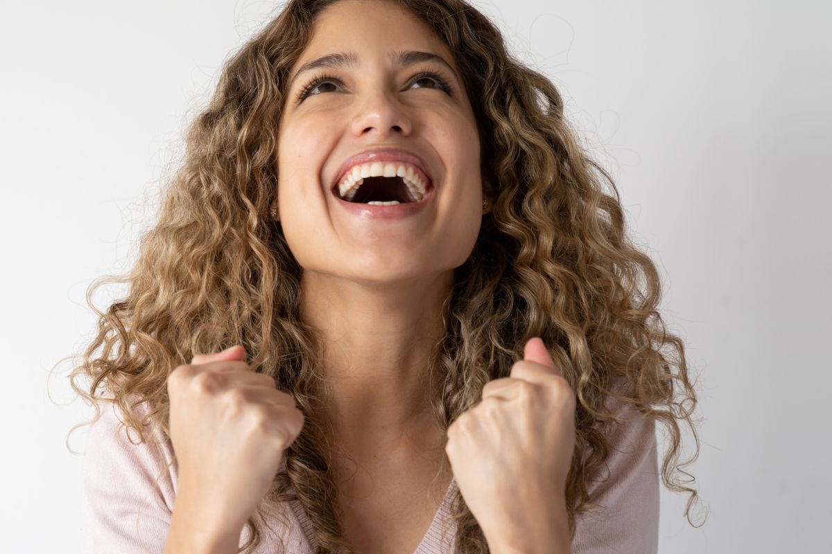 The image of a girl cheering with excitement indicating no spend month provides a sense of accomplishment that can inspire more financial challenges in the future.