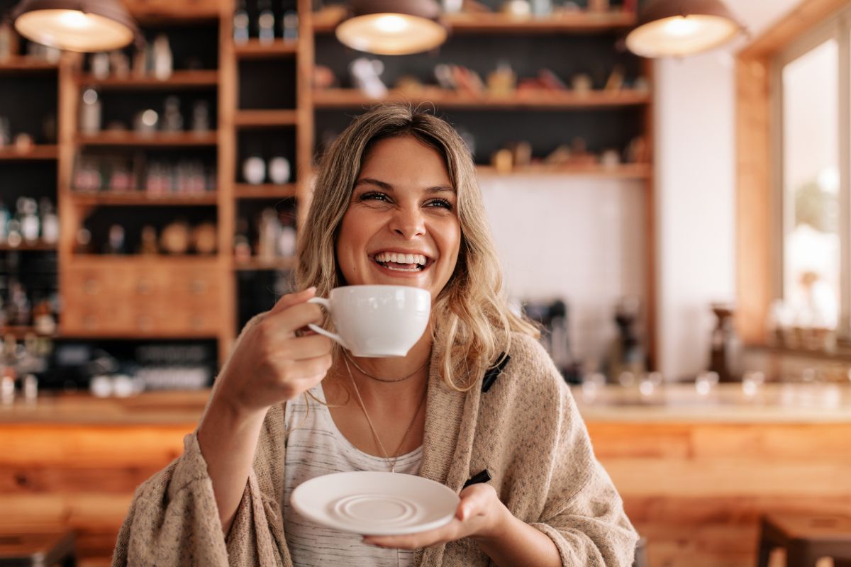 The photo shows a girl drinking a coffee at the shop indicating that rewarding yourself for milestones keeps you motivated without ruining your progress.