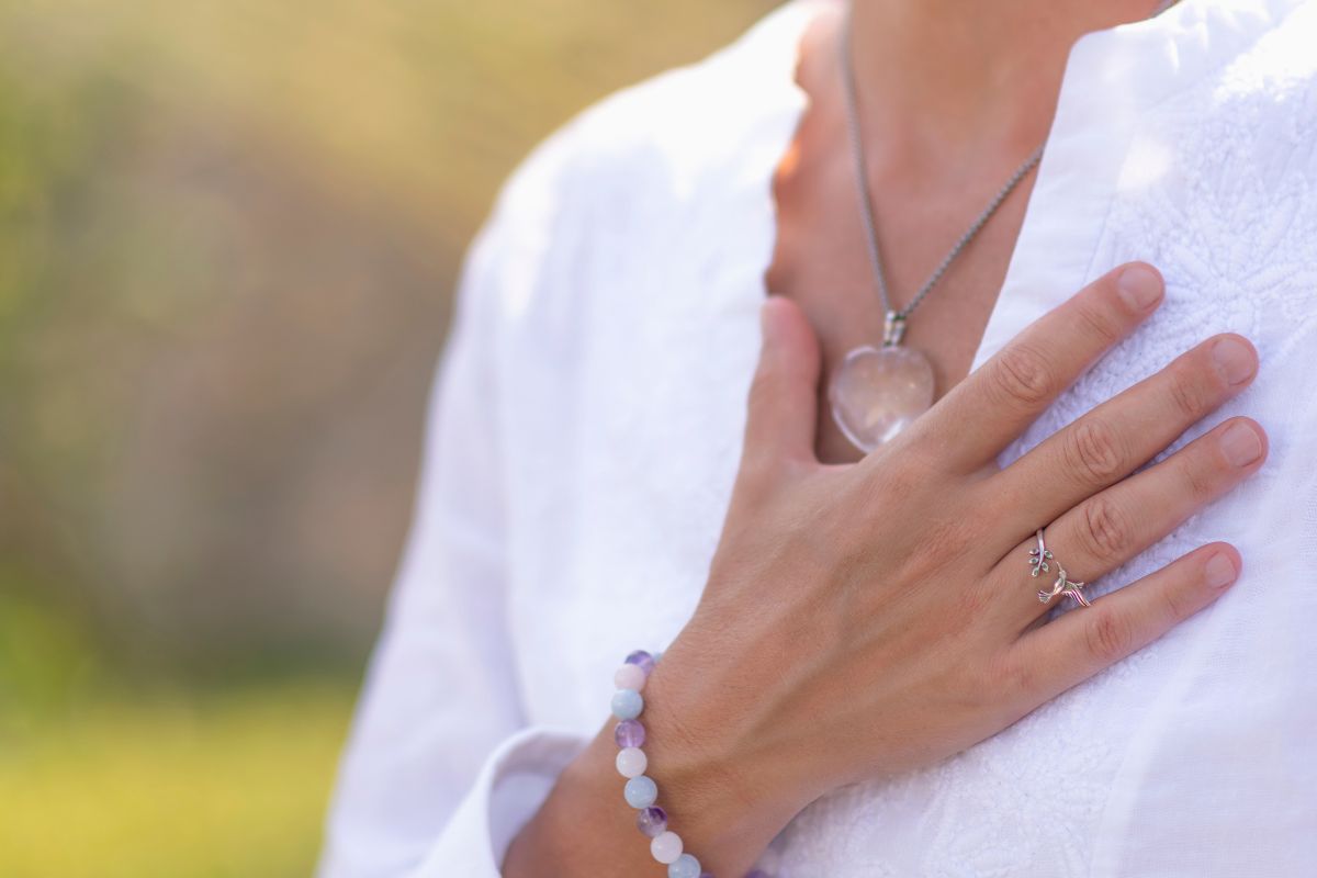 The photo shows a girl putting her hand on her chest indicating that staying grateful for every step forward makes savings money feel more rewarding.