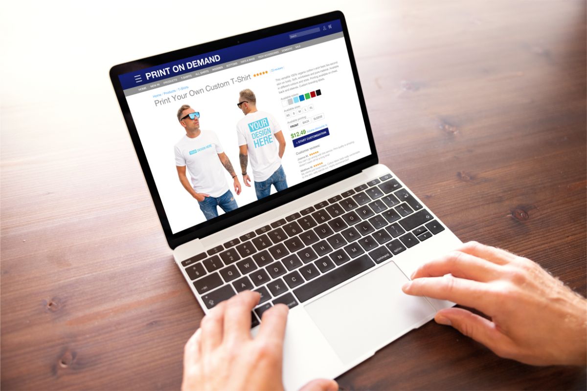 The photo tells about a man's hand using a laptop with a screen display which refers to designing your products to make your store look professional and keep customers coming back.