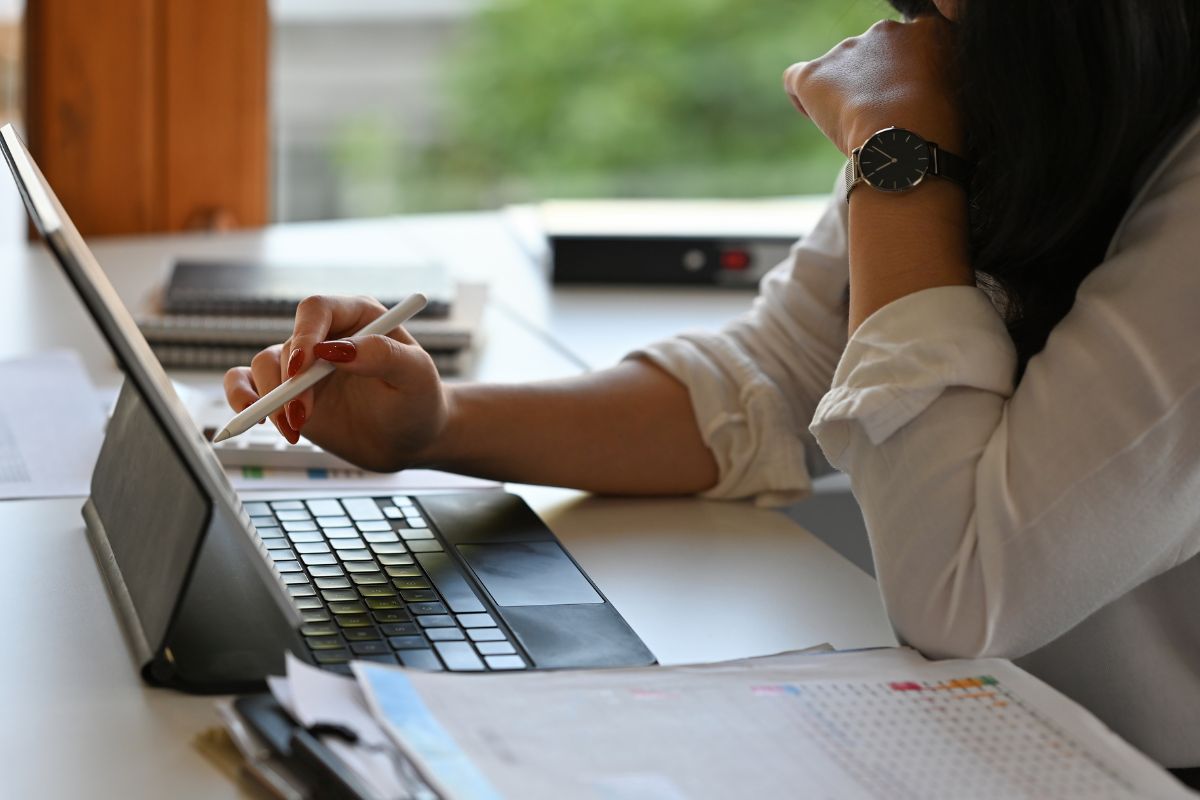 The picture shows notebooks, clipboards, and a girl using a tablet device while pointing it with a pen which refers to analyzing performance and scaling up to help you see what's working and not.