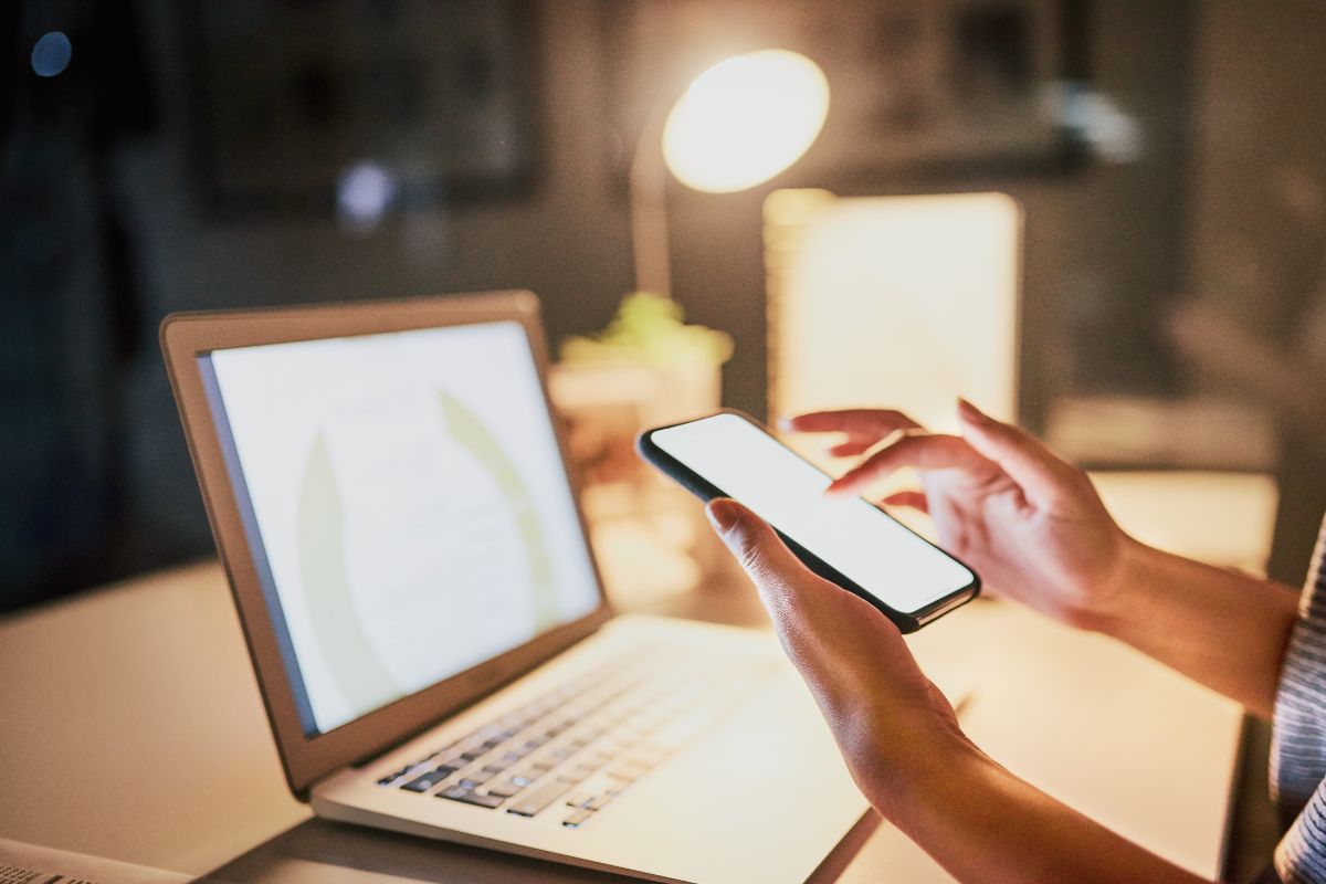 The picture tells about a laptop and a girl's hand using a phone which refers to scale through marketing and branding and can take your side hustle from part-time to full-time income.