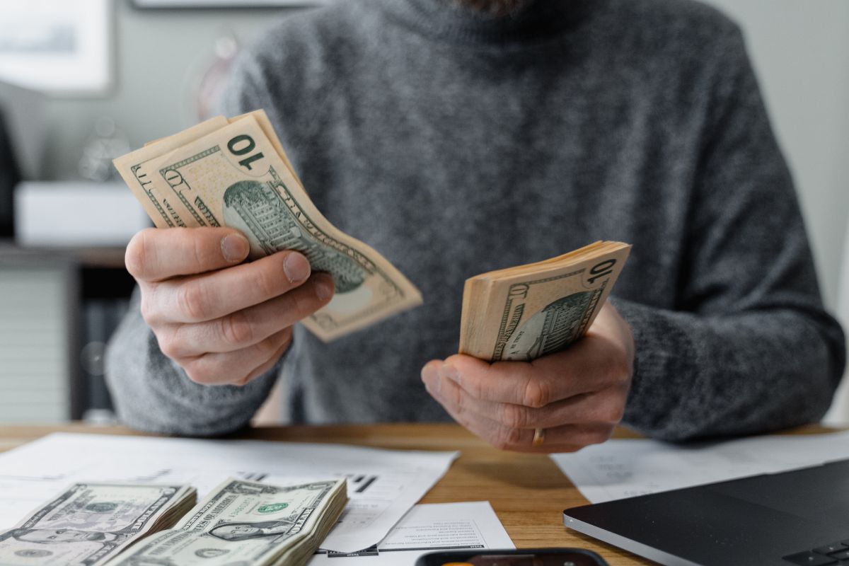 The image shows a man's hand with a strong financial foundation.