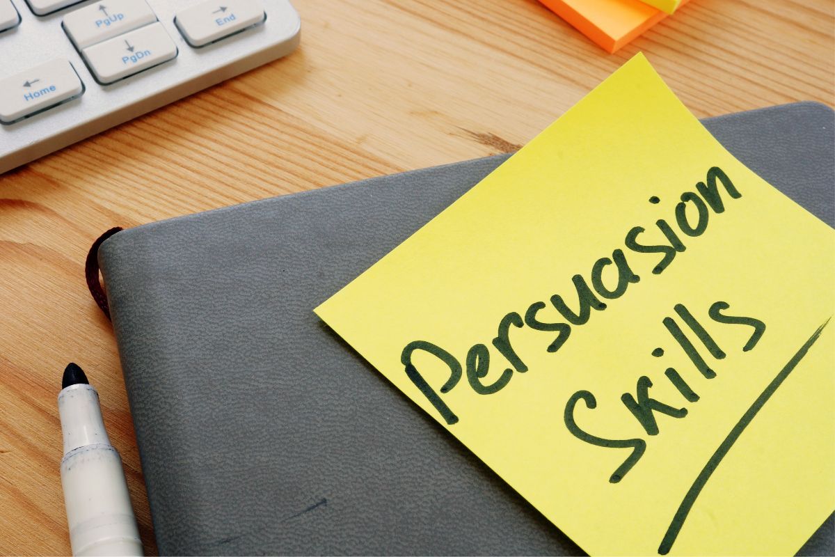 The image of a notebook and paper with persuasion skills written.