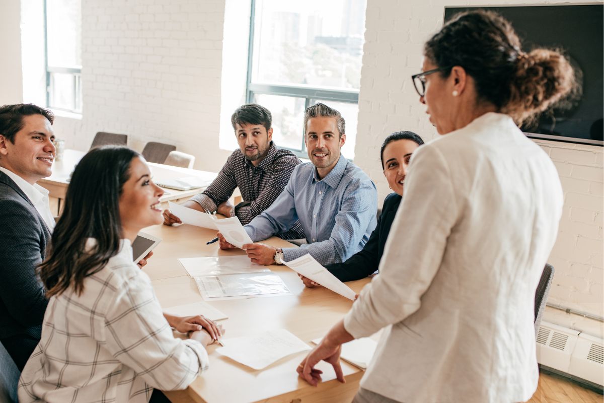 The photo shows a woman briefing her team management.