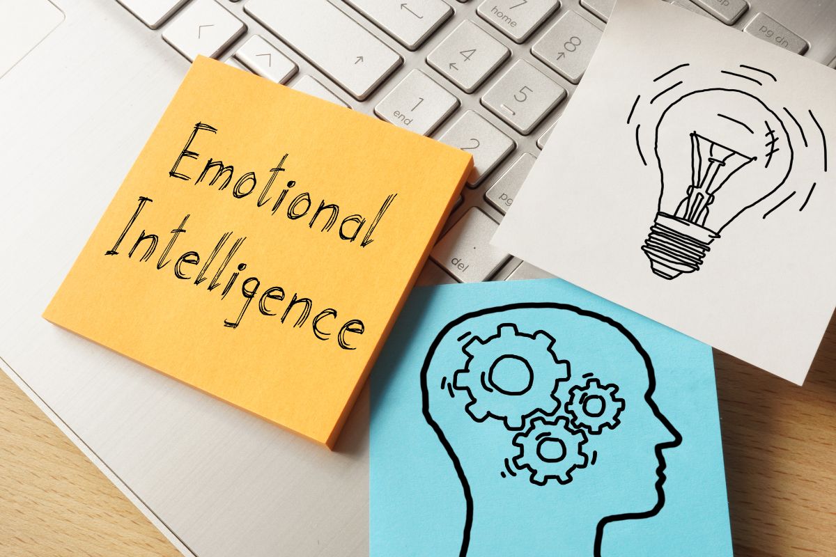 The picture of a laptop and paper with emotional intelligence written.