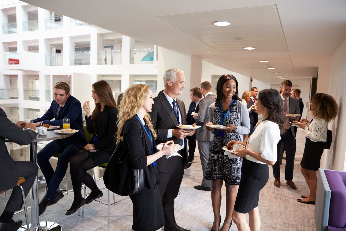 The picture shows a group of people talking together while having snacks at the building which refers to networking and relationship building can create multiple sources of income.