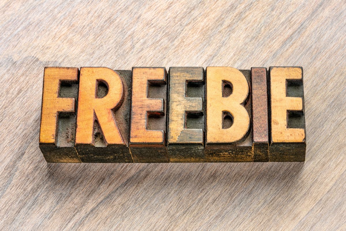 The photo shows a wooden letter on the table indicating that finding the best freebies in your city is a great way to have fun without spending money.