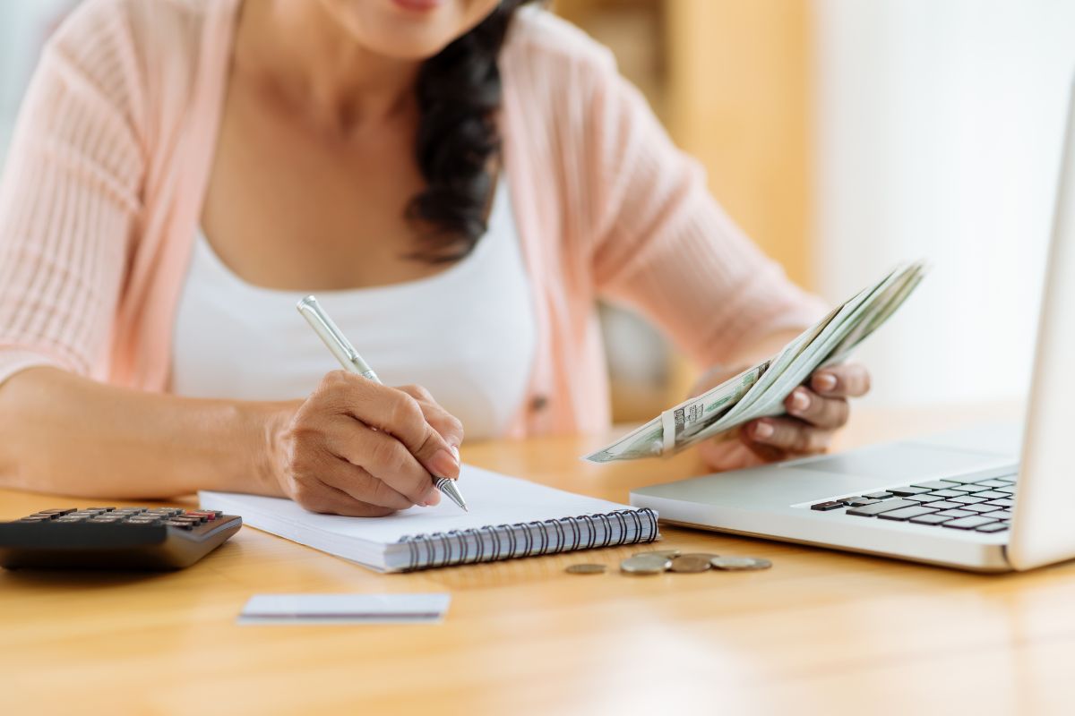 The photo shows a woman checking her weekly budget.