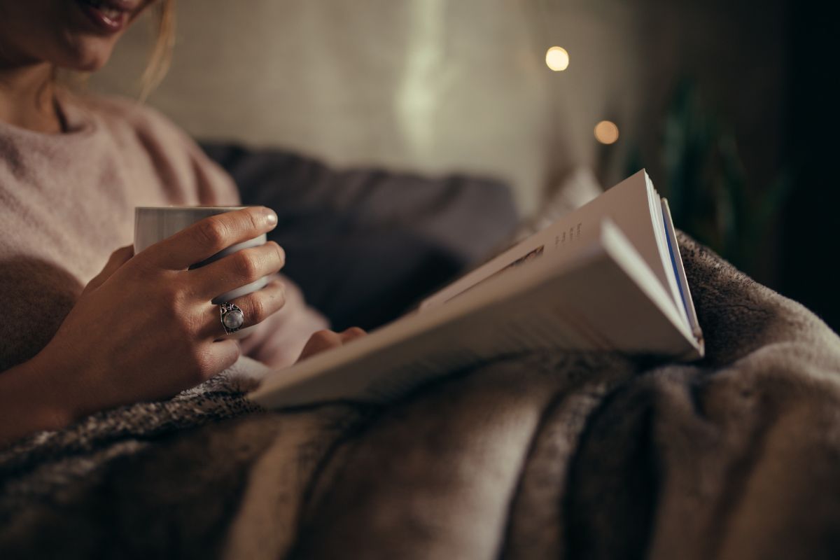 The photo tells about a girl reading a book while having a coffee which means finding alternative activities to shopping makes a big difference in financial habits.