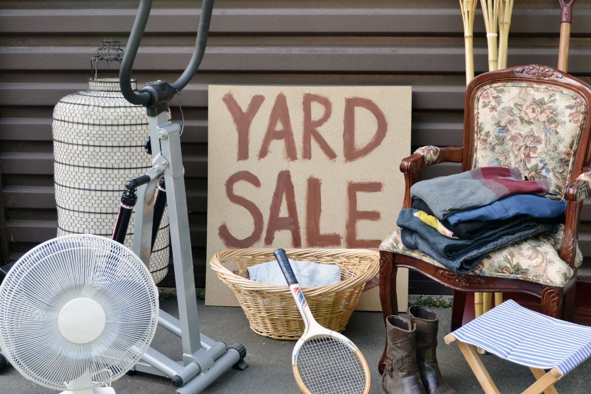 The image is about stuff and a board with yard sale wording.