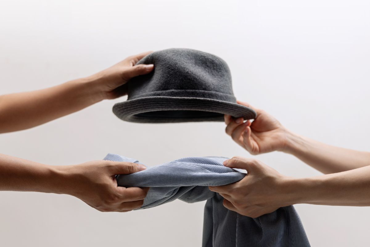 An image of two women's hands swapping stuff.