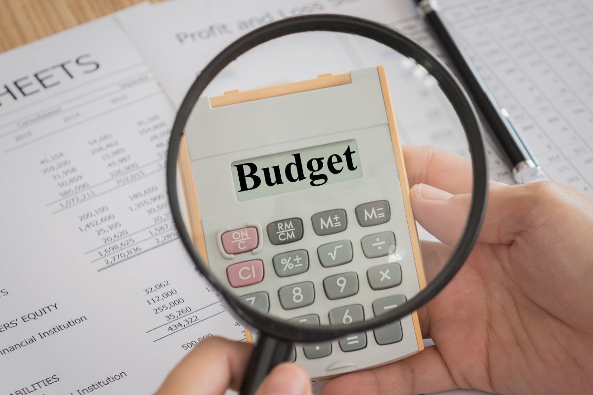 An image of a man's hand making a budget.