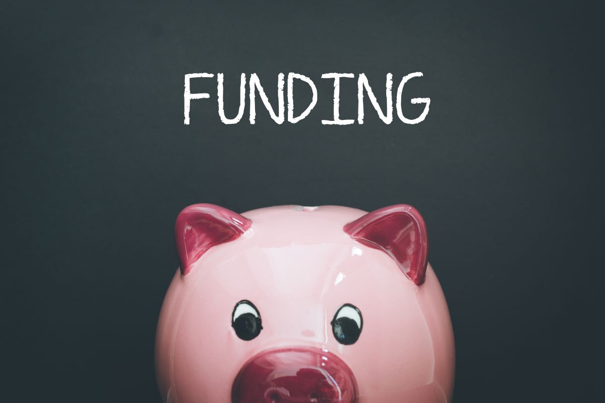 The photo of a piggy bank and funding wording.