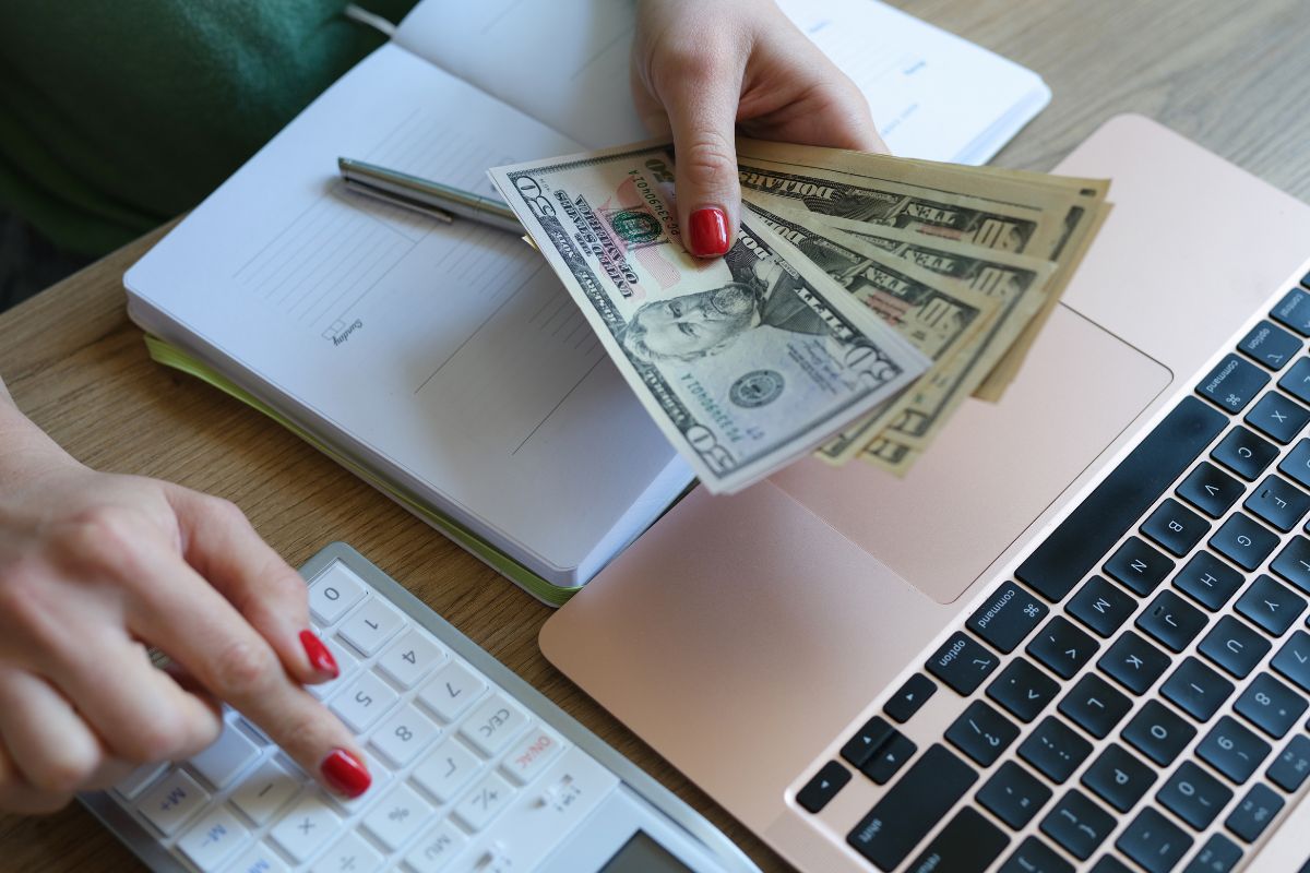 An image of a woman's hand budgeting the money.
