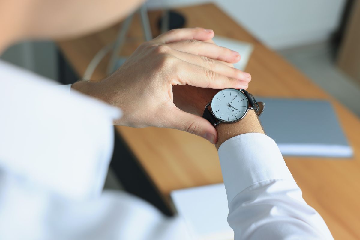 The image is about a man's hand tracking his hours worked.