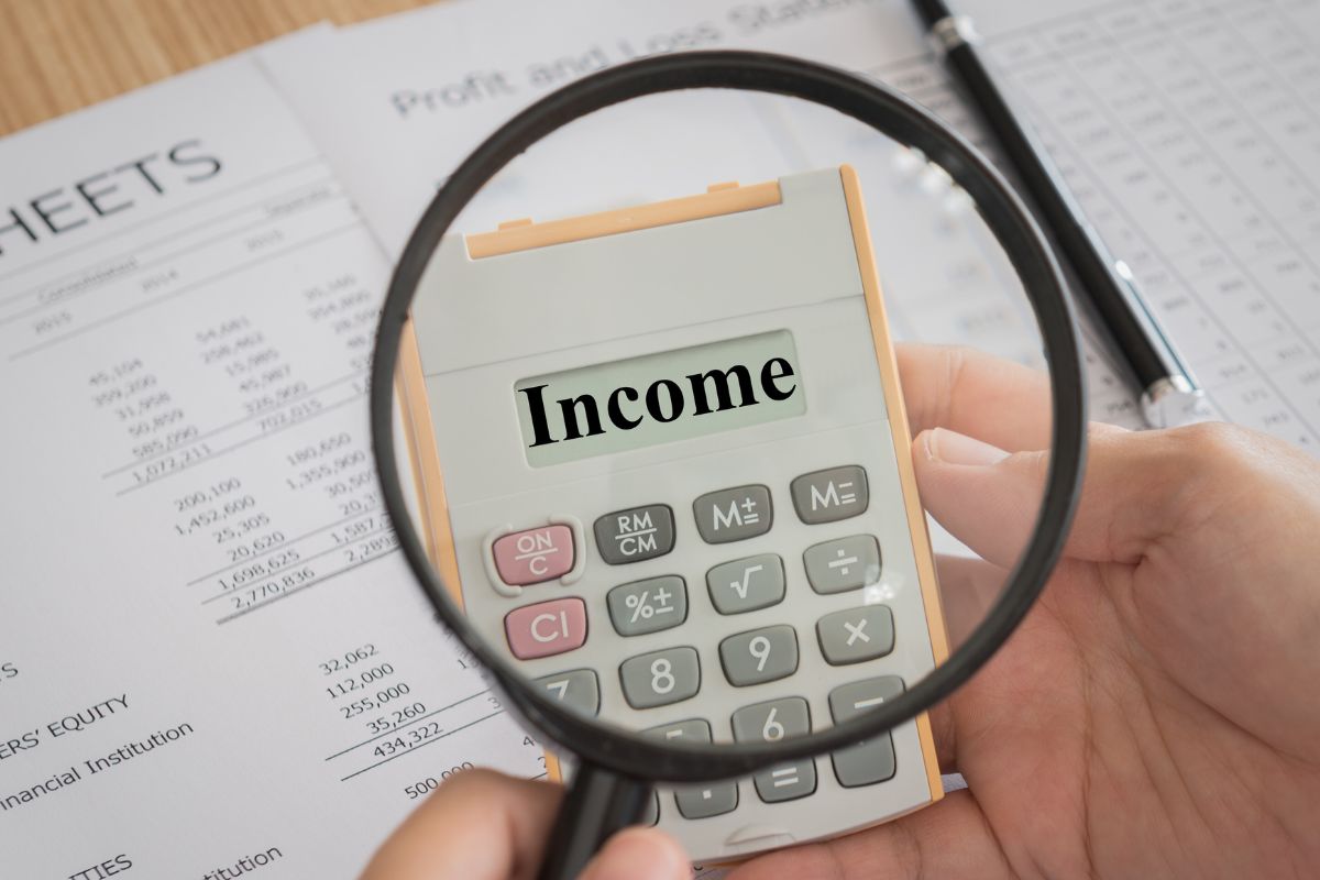 The picture shows a man's hand calculating income.