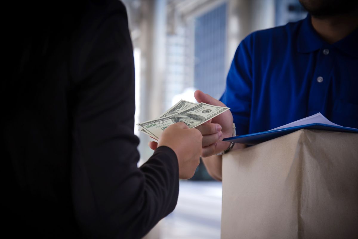 The photo shows a man paying in cash.