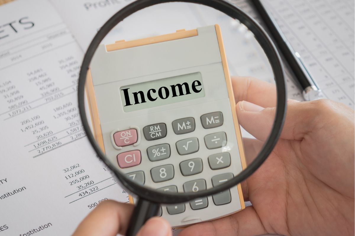 The photo shows a man holding a calculator with income wording.