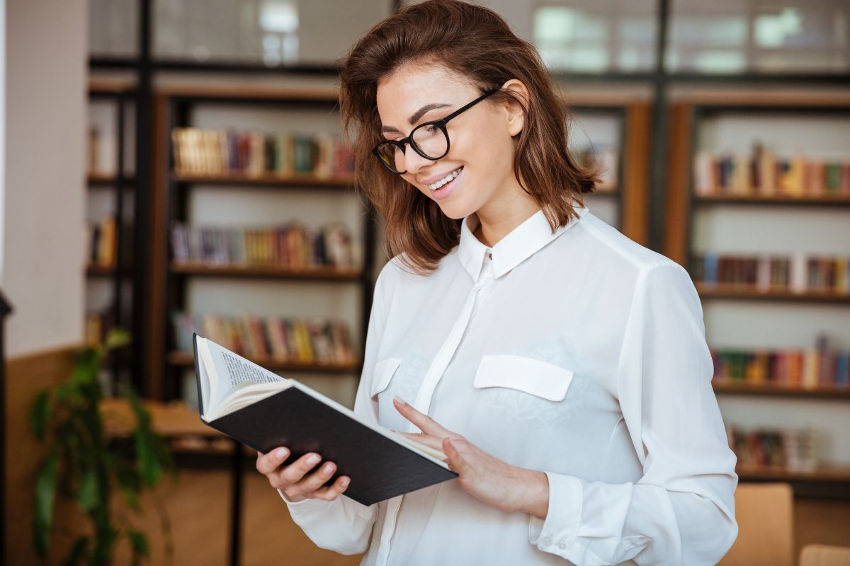 The picture shows books on the shelves and a girl reading a book which means reading and learning continuously helps you spot good opportunities and avoid costly mistakes.