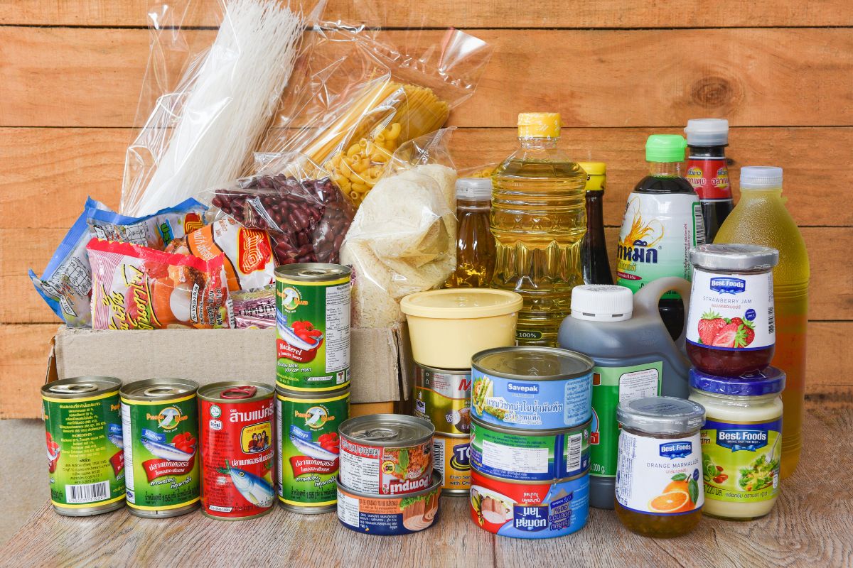The image tells about different kinds of canned goods, oils, pasta, and more which means purchasing non-perishable items with friends and splitting the cost is a simple way to stretch your budget while keeping grocery costs down.