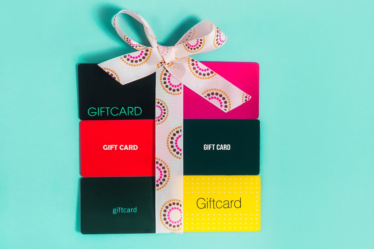 The photo shows a bulk of cards with a ribbon which means getting bulk gift cards at warehouse clubs is an easy way to save without changing your shopping habits. 