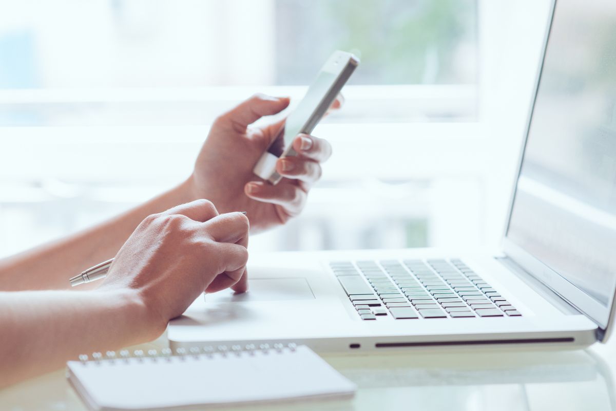 The photo shows a notebook and a girl using a laptop and phone which refers to batching similar tasks into power hours, which helps increase earnings by staying focused on revenue-generating tasks.