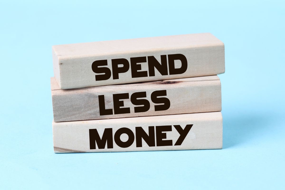 The image shows spend less money wording on rectangular wood.