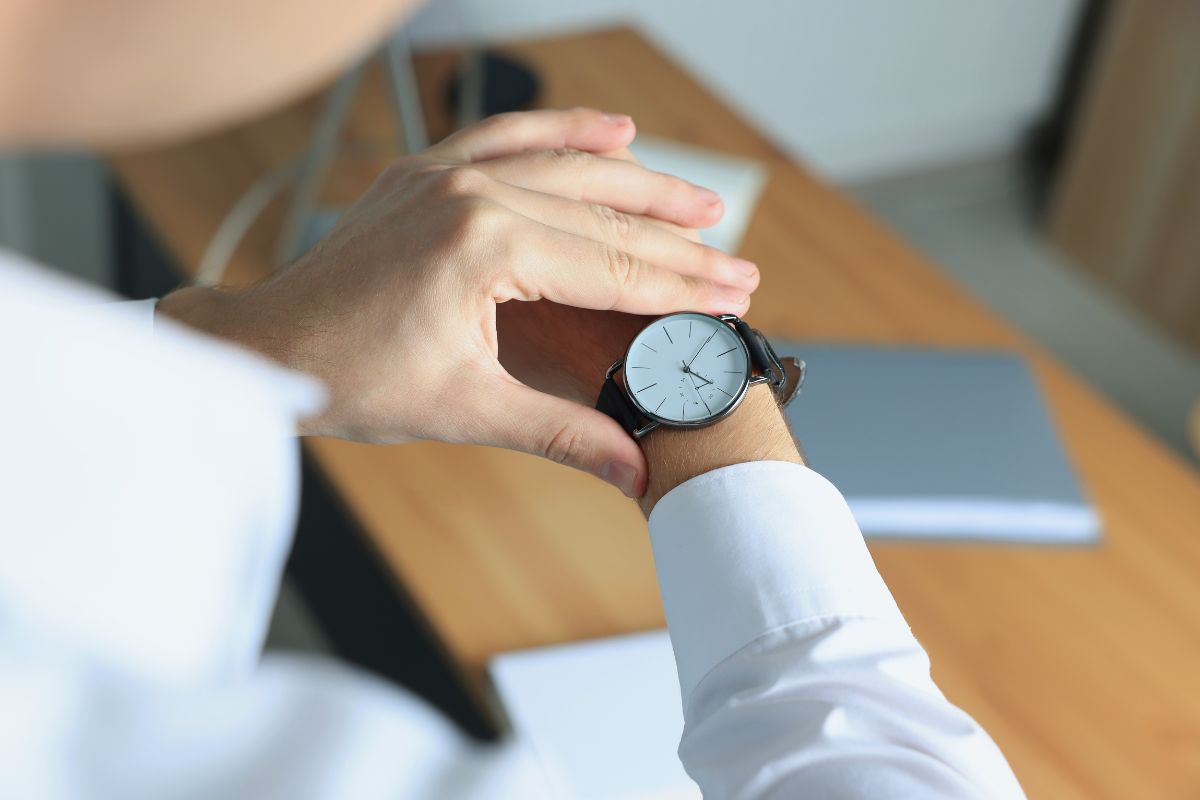 The picture shows a man's hand checking his watch.