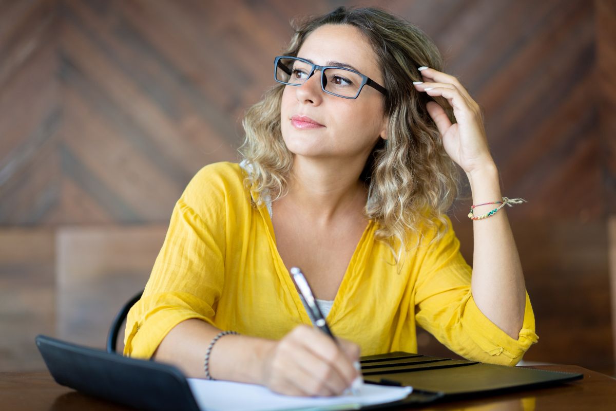 The picture shows a woman writing daily earnings goals.