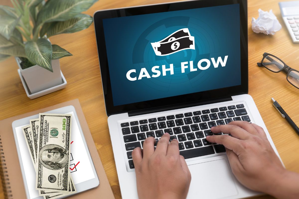 The photo shows a man's hand setting up cash-flow checkpoints.