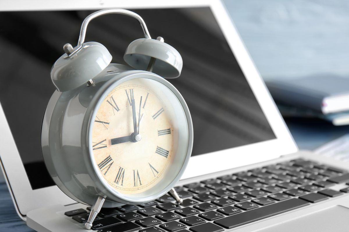 The photo of a clock and a laptop.