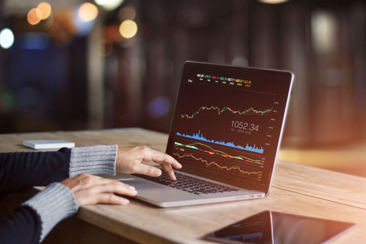 The photo shows a laptop device and a girl's hand using a laptop with a screen display indicating that trading stocks and options can be a great way to make money online.