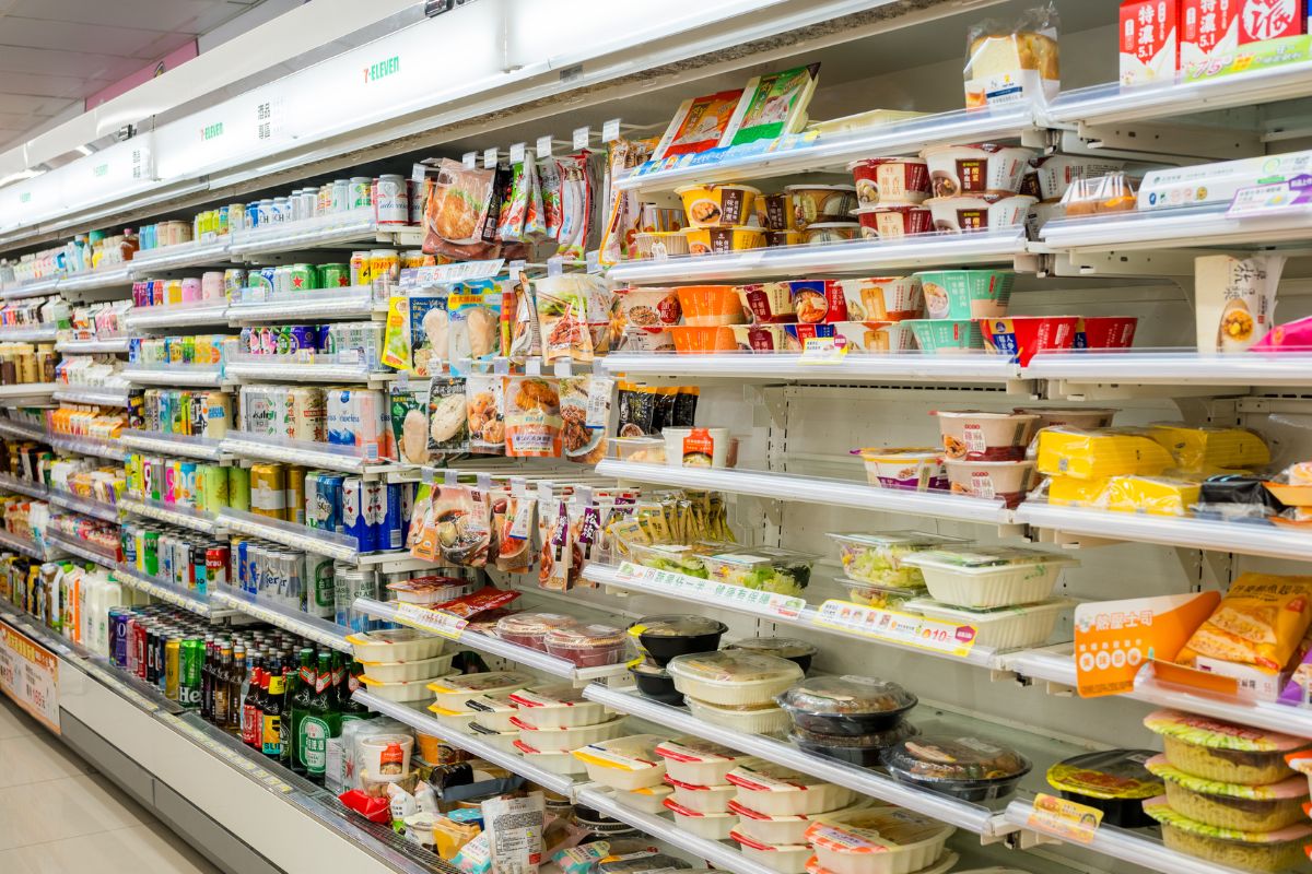 The image shows product displays at the store referring to overpriced convenience store snacks that cost far more than buying bulk at the grocery store, keeping snacks at home can help avoid these costly stops.