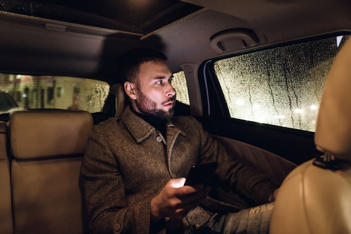 The photo of a passenger inside a car referring to frequent Uber that costs more than public transit, using rideshares only when necessary helps keep spending in check.