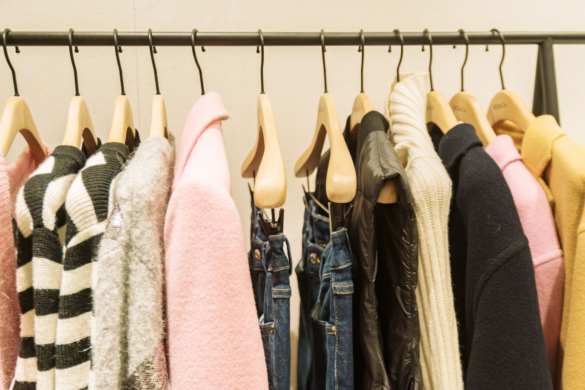 The picture shows hung clothes which refers to fast fashion purchases that don't last and can be a waste of money, choosing durable and classic styles can save money over time.