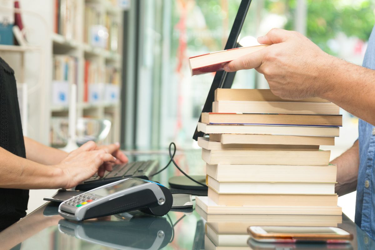 The picture is about a man's hand buying books.
