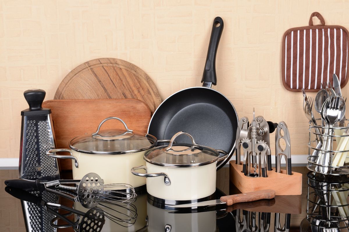 The picture shows pans, spoons forks, and more at the table which refers to fancy kitchen gadgets that end up gathering dust, a simple set of essential tools is often all that is needed to prepare meals.
