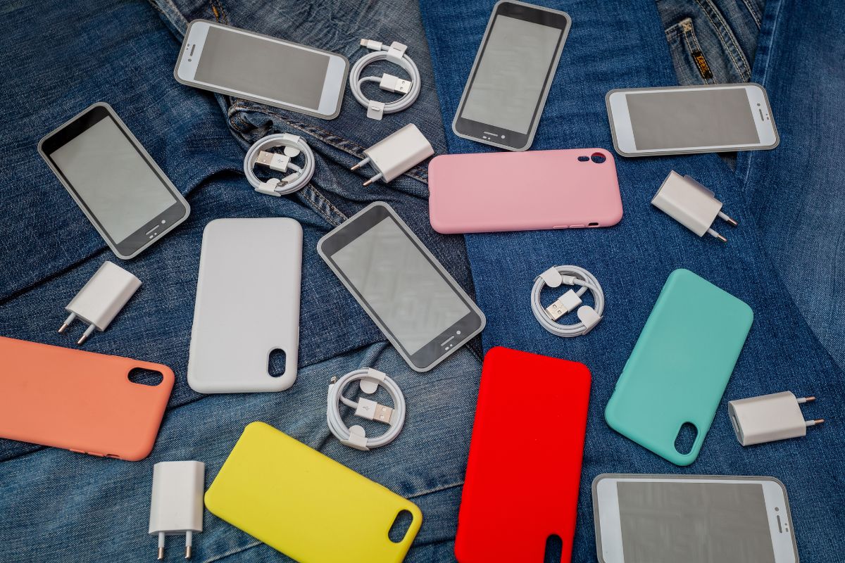 The picture shows a phone case, adaptors, chords, and tempered glass which refers to extra phone accessories that go unused leading to wasted money, focusing on the accessories that will truly benefit your phone's functionality can save money.